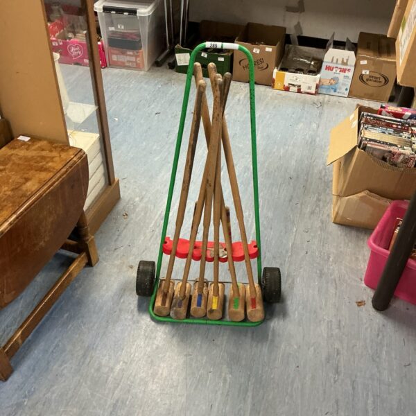 Vintage croquet set with wooden mallets and trolley for easy transport.