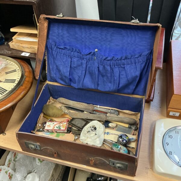 Vintage curios case filled with antique jewellery and carving knives.