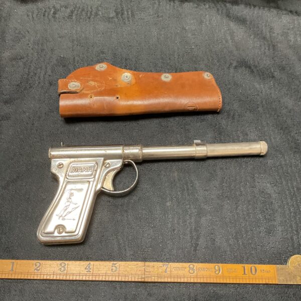 Vintage Diana Gat Gun with leather holster, collectible toy.