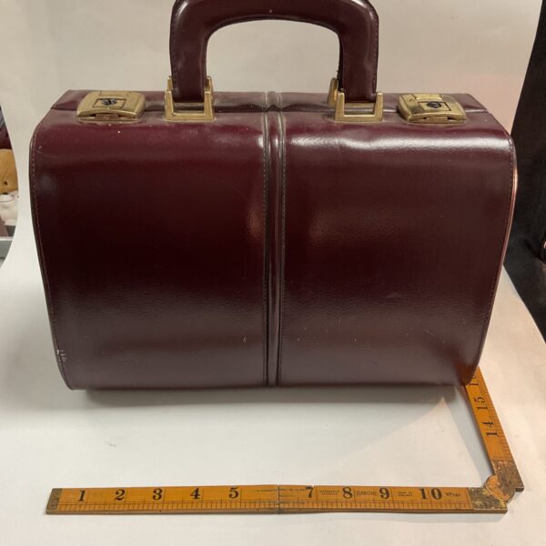 Front view of a vintage red leather doctors bag.