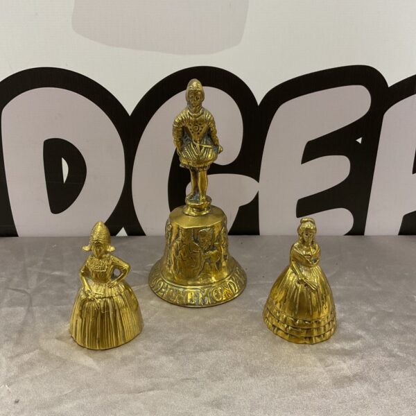 Set of three vintage brass Dutch bells with figurines.