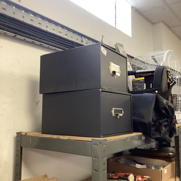 Two vintage metal filing drawers for office storage.