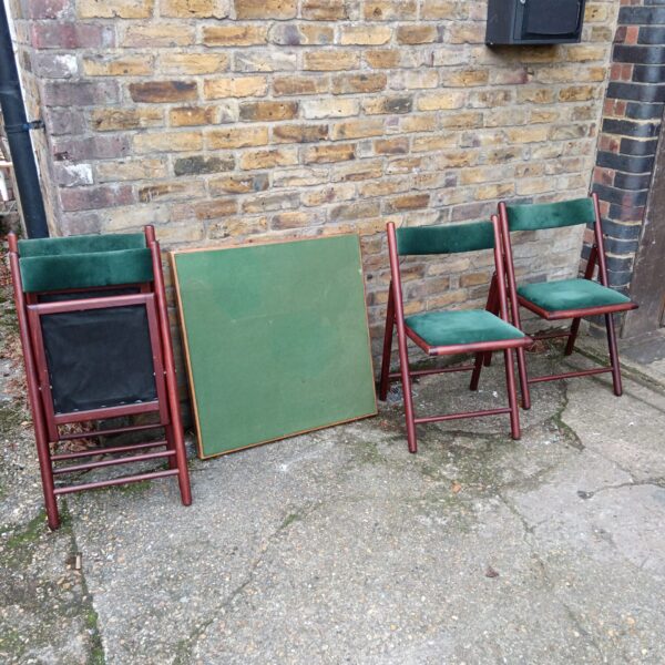 Vintage folding card table and four chairs in dark wood and green vinyl.