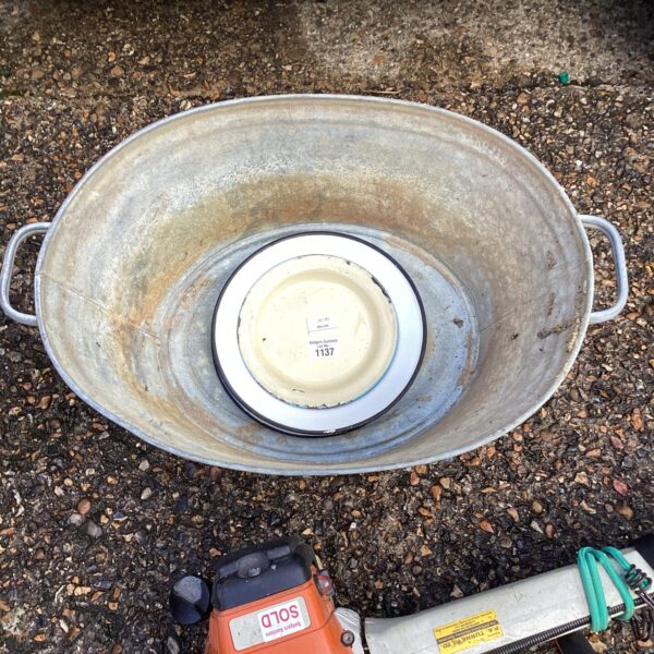 Vintage galvanised bath with enamel plates, rustic farmhouse style.