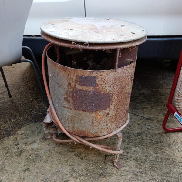 Vintage galvanised gas heater with rust and wear.