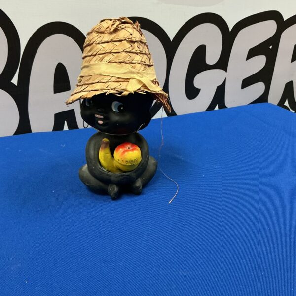 Vintage hula girl figurine with nodding head and fruit.