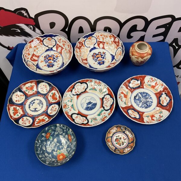 Overview of a vintage Imari china collection with plates and bowls.