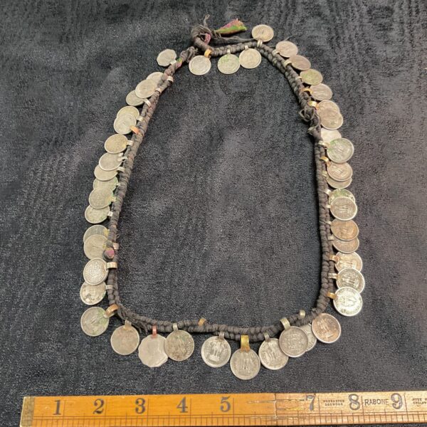 Close-up of a vintage Indian coin belt with linked coins.