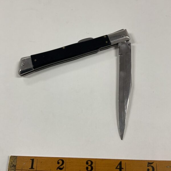 Vintage Italian pocket knife with dark handle and folding blade.