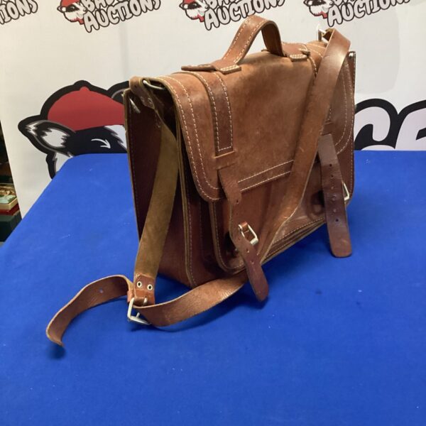 Front view of a vintage brown leather satchel with buckle closure.