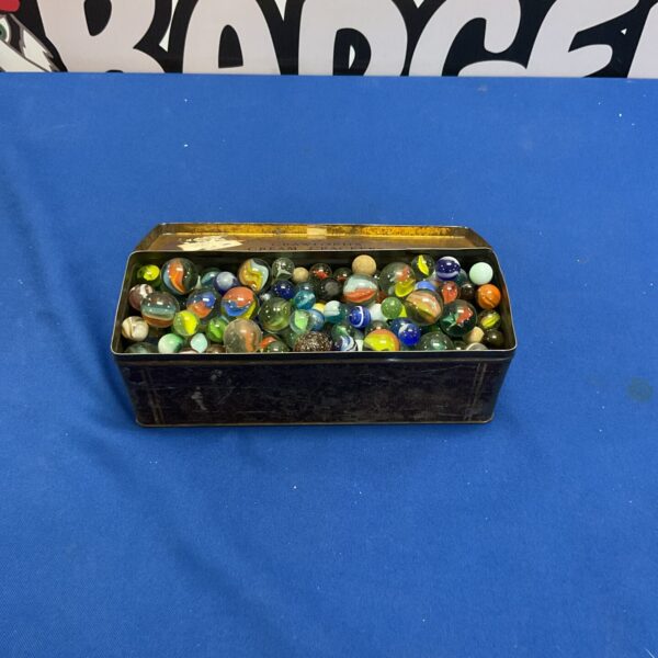 Vintage glass marbles in a metal tin, collectible toy lot.