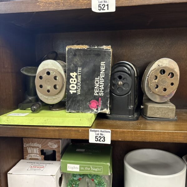 Close-up of a vintage metal pencil sharpener on a tabletop.