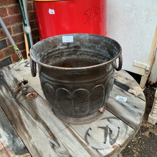Weathered vintage metal planter for garden use.