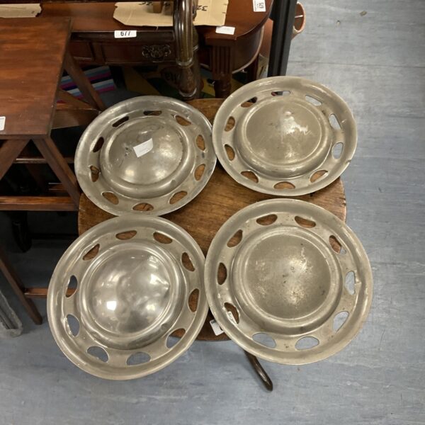 Set of four vintage mini wheel trims for classic cars.