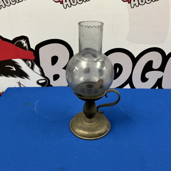 Vintage brass oil lamp with clear glass shade.