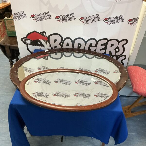 Pair of vintage oval mirrors with wood frames.