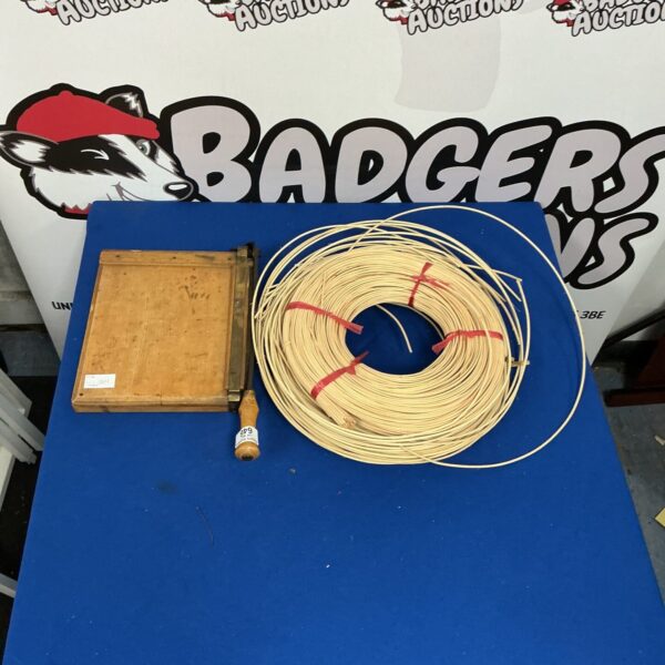 Vintage paper cutter with a roll of natural raffia.