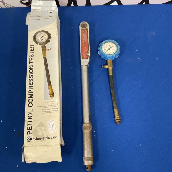 Vintage petrol compression tester and torque wrench for automotive repair.