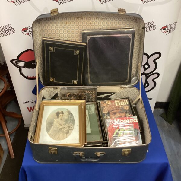 Vintage suitcase for storing photo albums and framed photographs.