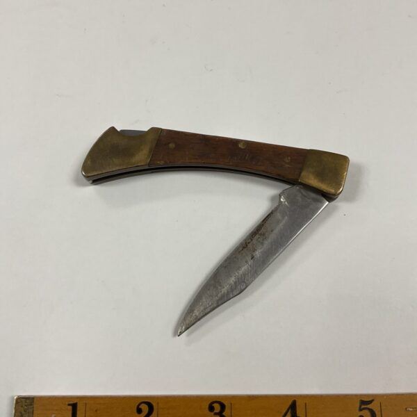 Vintage pocket knife with brass and wood handle.
