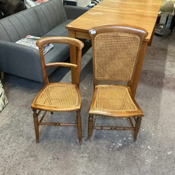 Two vintage raffia chairs with woven seats and wooden frames.