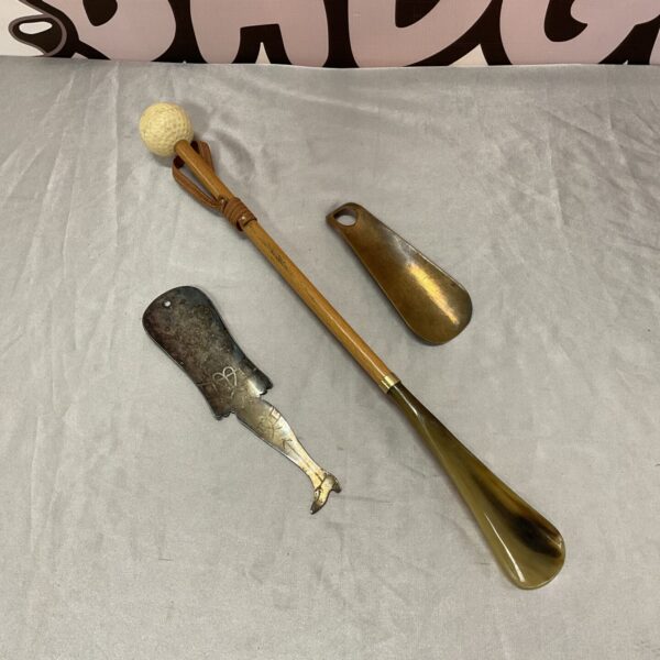 Vintage shoe horn lot with golf ball design and metal construction.