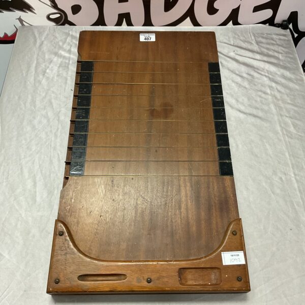 Vintage shove ha'penny board with numbered slots for gameplay.