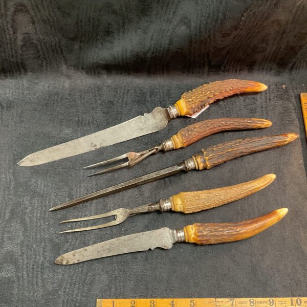 Vintage stag horn carving set with silver collars and sharpening steel.