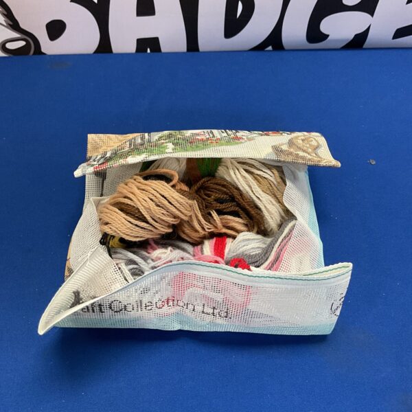 Vintage tapestry kit with colourful wool threads and needle.