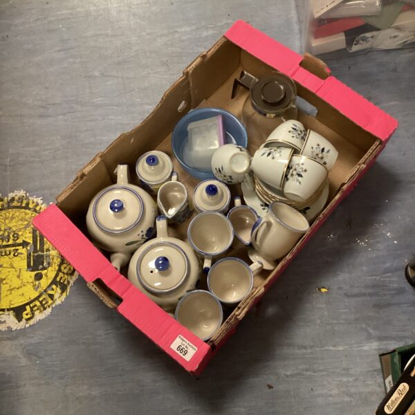 Vintage porcelain tea set with blue floral details on a white background.
