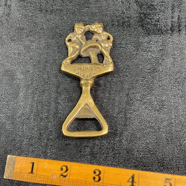Vintage brass Thirsty Pixies bottle opener with pixie design.