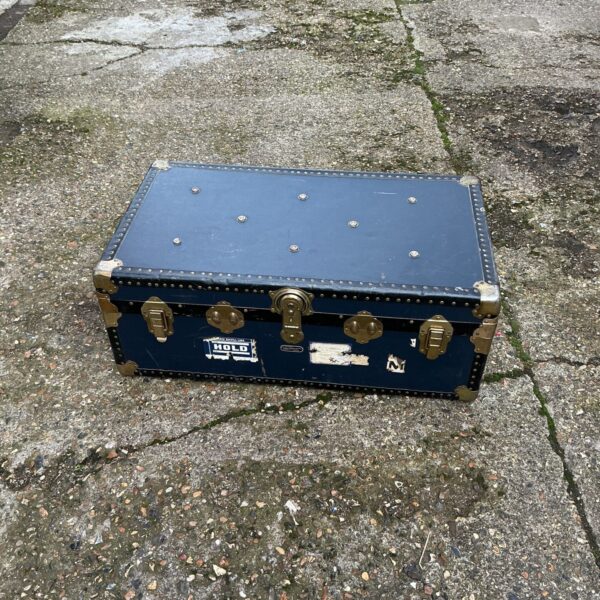 Front view of a vintage travel trunk with canvas exterior.