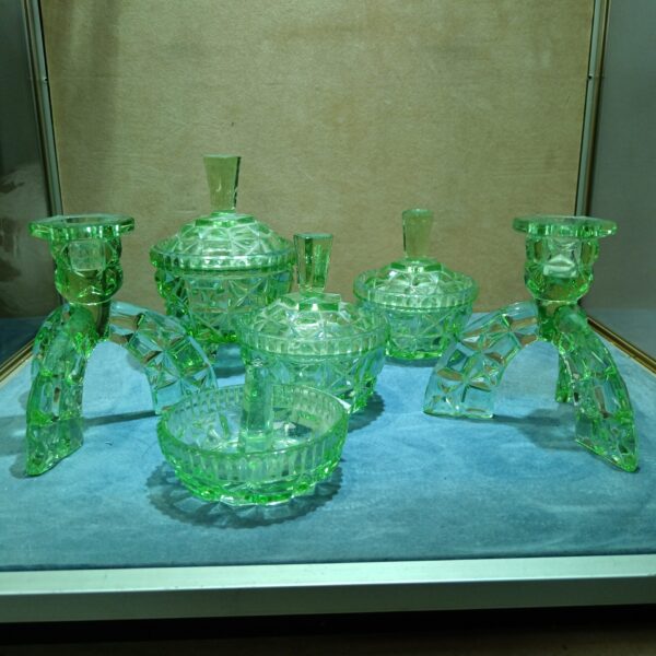 Vintage uranium glass dressing table set with green glow.