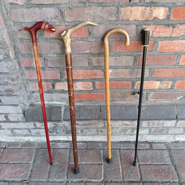Group of four vintage walking sticks with unique handles.