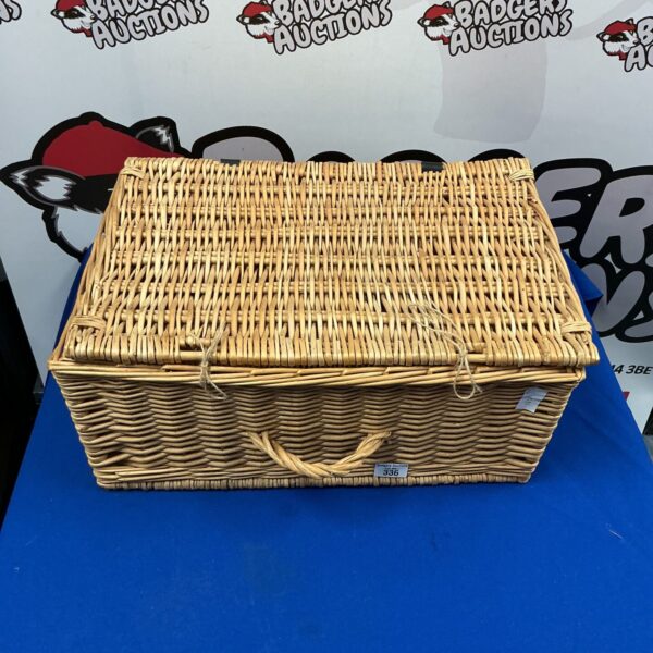Vintage wicker picnic basket with a sturdy handle.