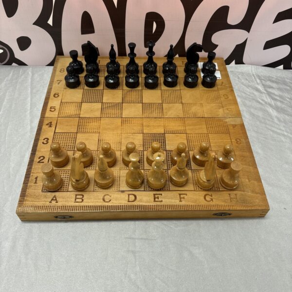 Vintage wooden folding chess set with pieces displayed.