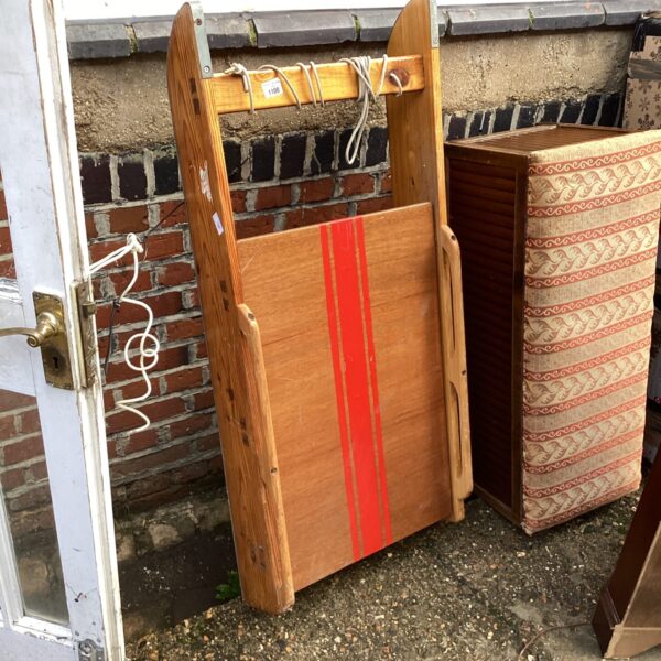 Vintage wooden sled with red stripe, antique winter toy.
