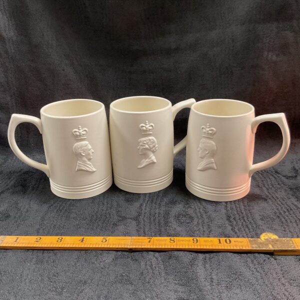 Group of three vintage Wedgwood coronation mugs with royal emblems.