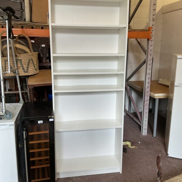 Tall white bookcase offering ample storage and display space.
