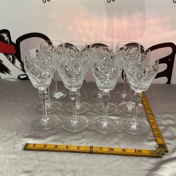 Set of twelve vintage Whitefriars crystal wine goblets on display.