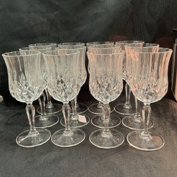 Set of twelve vintage Whitefriars wine goblets on display.