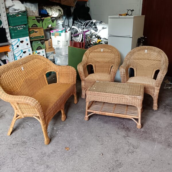 Vintage wicker armchair from a conservatory set, showing wear.