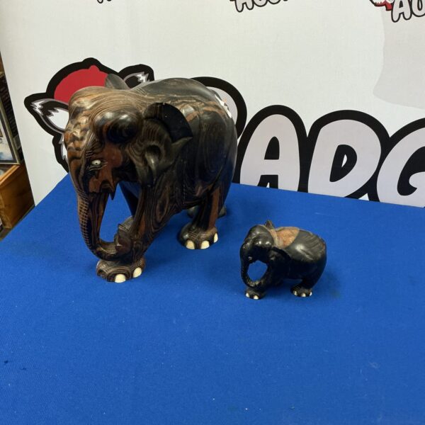 Pair of carved wooden elephant ornaments for home decor.