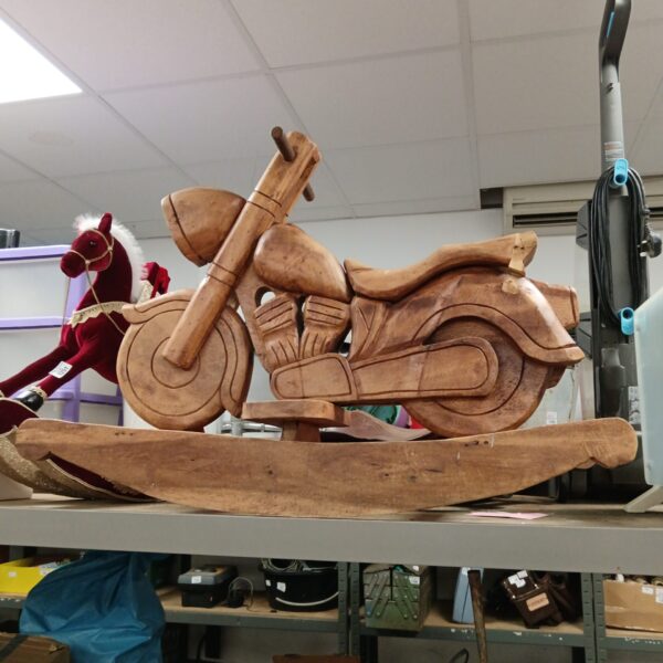 Hand-carved wooden rocking motorbike, a unique folk art toy.