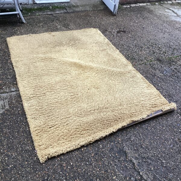 Vibrant yellow shagpile rug with a deep pile texture.