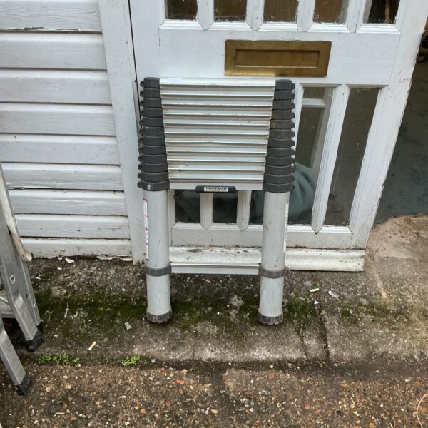 Used Youngmans telescopic aluminium ladder leaning against a wall.