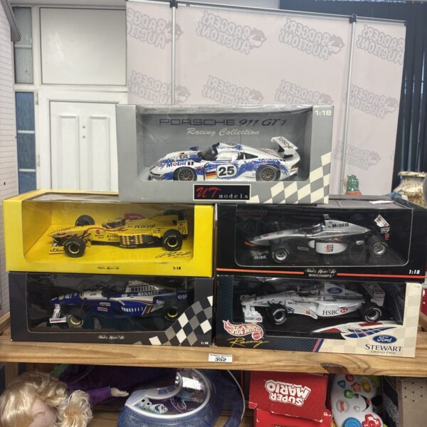 Lot of five 1:18 scale diecast model cars in boxes.