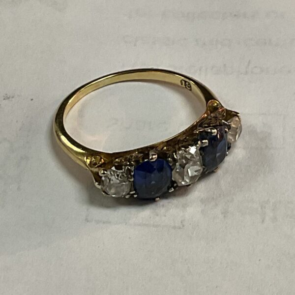 Close-up of 18k gold ring with sapphires and diamonds.