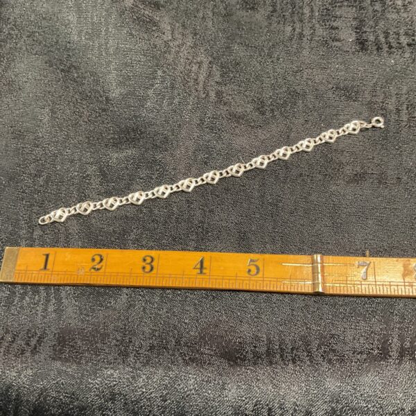 Close-up of a 925 silver heart link bracelet.