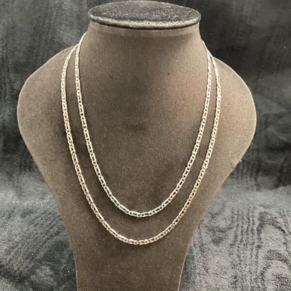 Two large link 925 silver necklaces displayed on a mannequin.